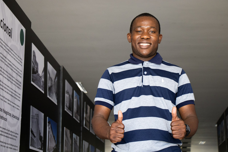 homem negro sorrindo e fazendo sinal de positivo para a foto